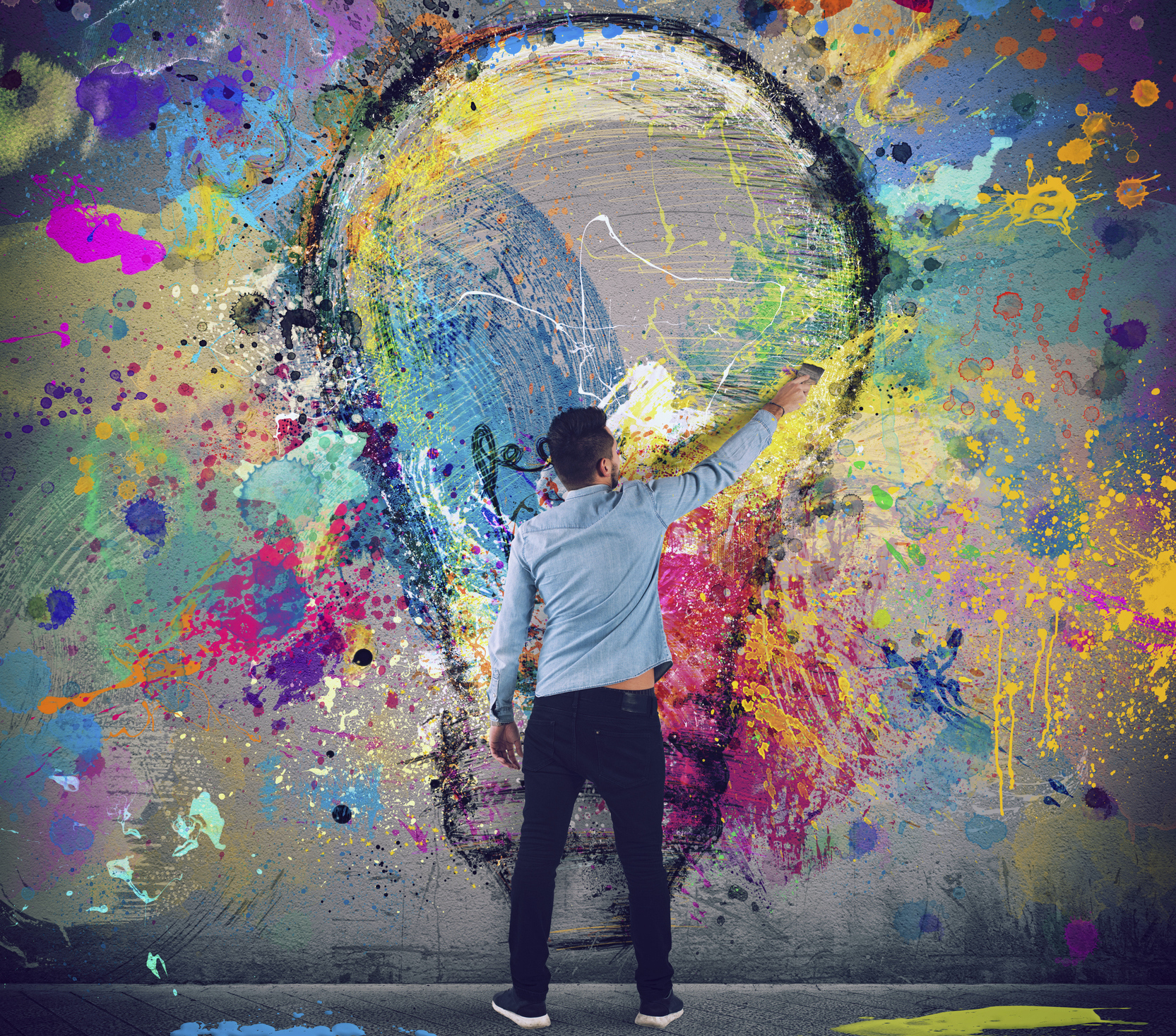 man painting a lightbulb on a wall