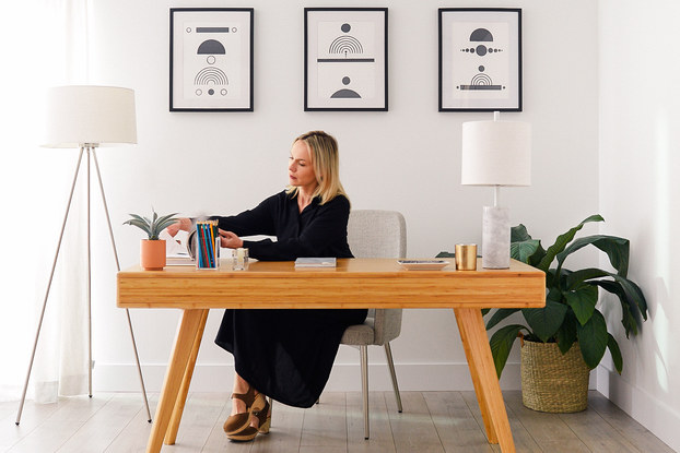 woman working at a fernish desk in home office
