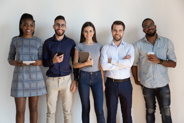 group of diverse coworkers standing in a line and smiling