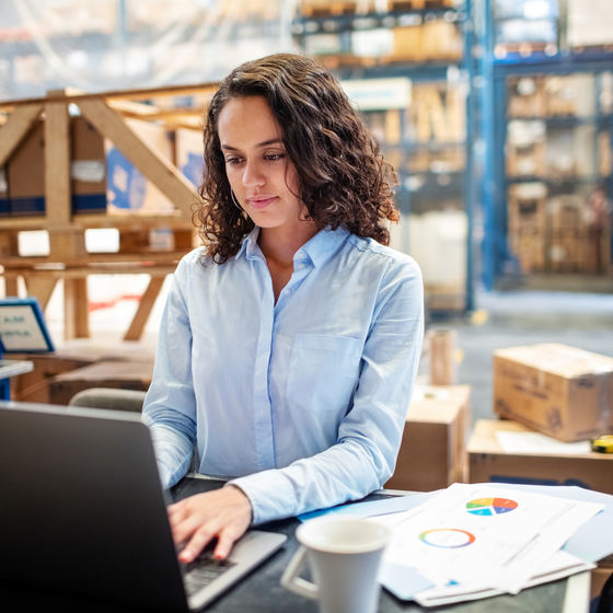 woman working on laptop in warehouse