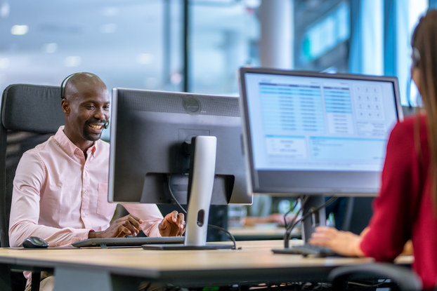 man and woman working on computers in a call center