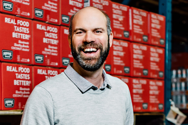 headshot of ian walker of hippie snacks in a warehouse