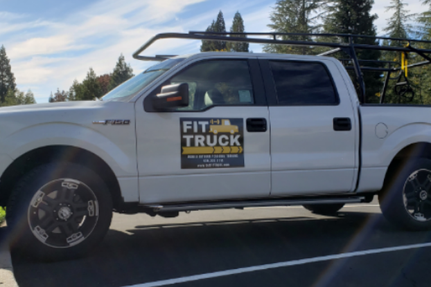 exterior of fit truck company car with logo on the door