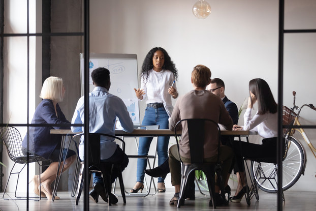 woman presenting to a team of people in a conference room