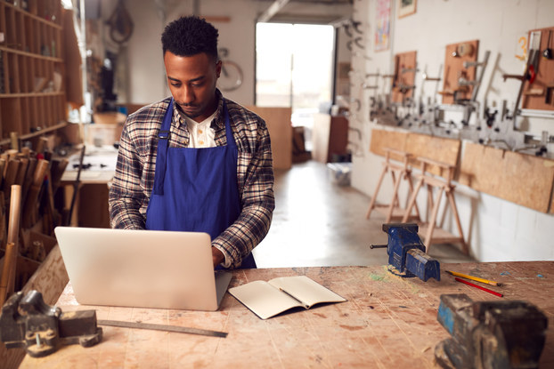 small business owner in studio working on laptop
