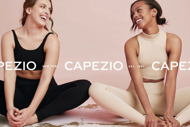 two women dressed in athletic wear stretching for dance
