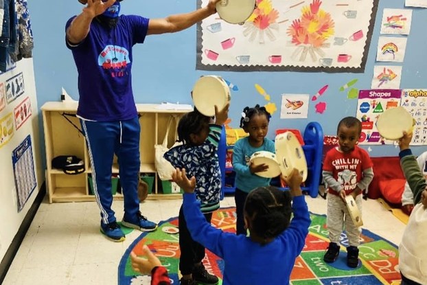 Move N Groove Kidz employee in a classroom working with young children.