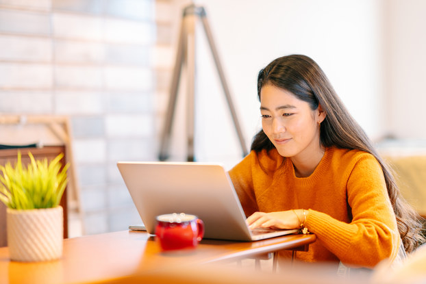 Woman working on laptop in her apartment.