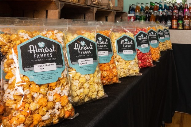 Almost Famous Popcorn bags of popcorn displayed on store shelves.