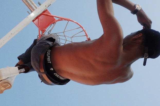 An upside-down shot of a model playing basketball wearing Culprit Underwear.