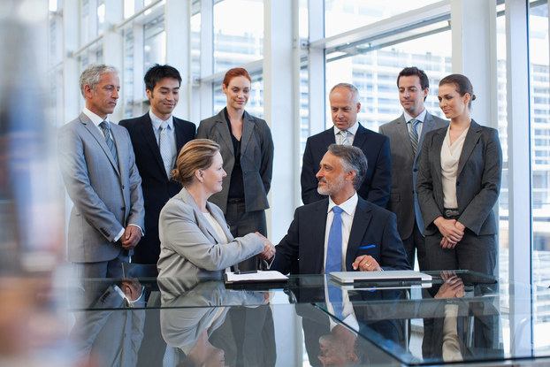 Business people shaking hands in conference room