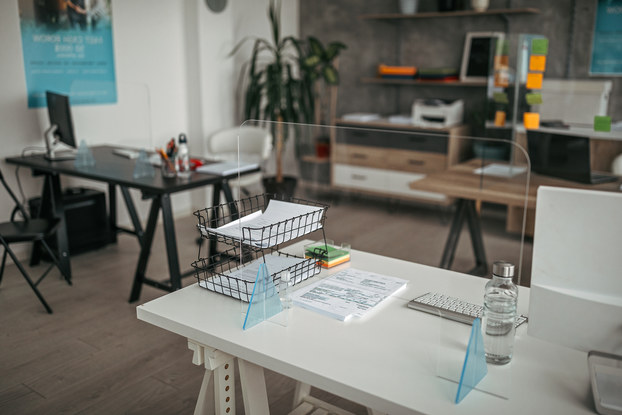 Office space with plastic partitions around each desk.