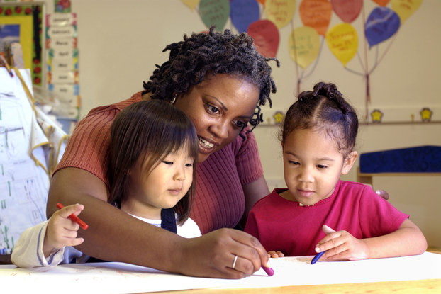 Daycare teacher draws with children