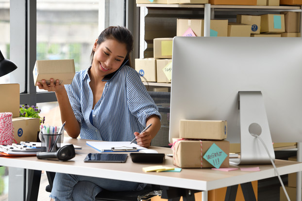 Woman entrepreneur processes online sale with product in hand