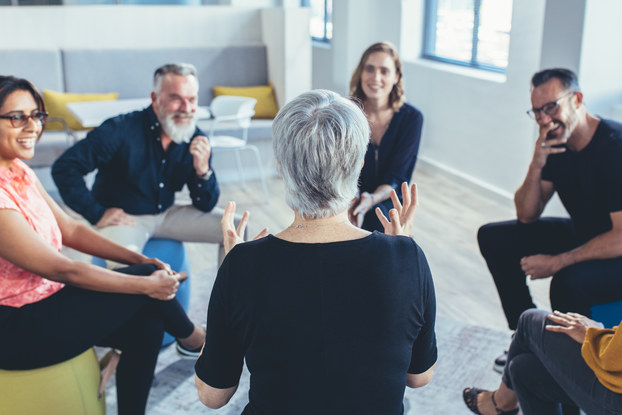 Group of business people sitting in circle and discussing in the office.
