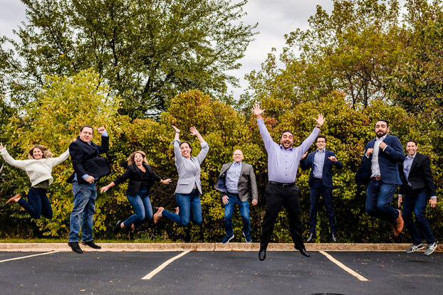 Business people pose happily in a parking lot