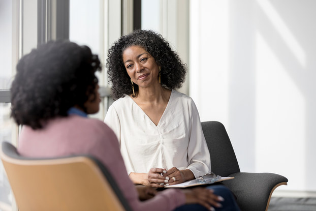 Mature counselor listens compassionately to client