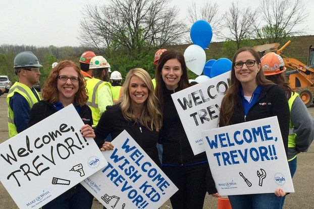 Women hold signs at outdoor event