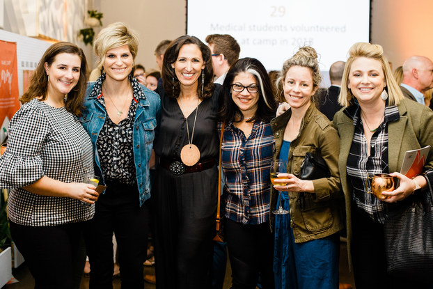 Smiling women pose at corporate event