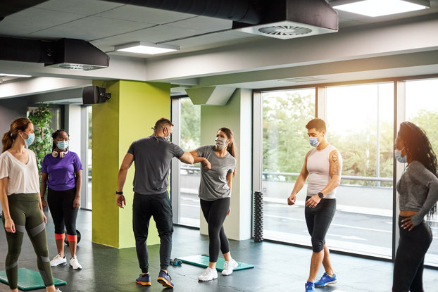 People exercising in a fitness studio with masks on.