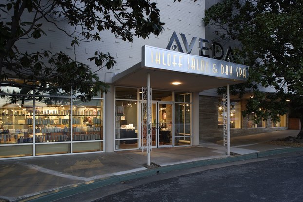 Products in the window of a storefront are illuminated at dusk.