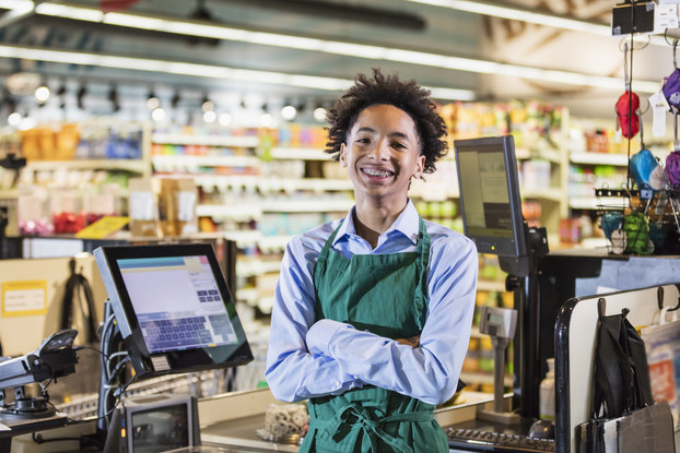 Adolescent boy at cash register in grocery store