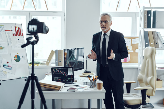 Senior man in business suit sharing his business experience while making social media video