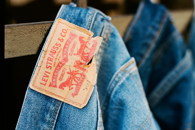 Pairs of Levi's jeans hanging from belt loop in a row.