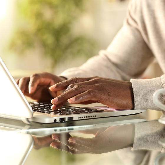 Person's hands typing on laptop.
