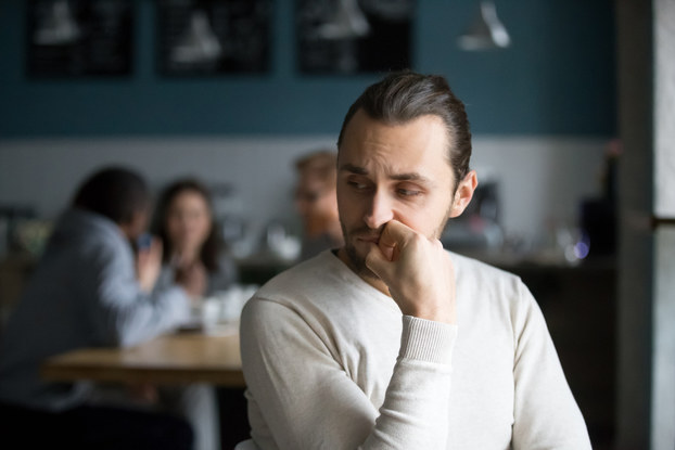 Upset male sits alone and appears upset.
