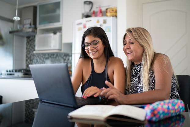 Two people working on project on laptop in a home