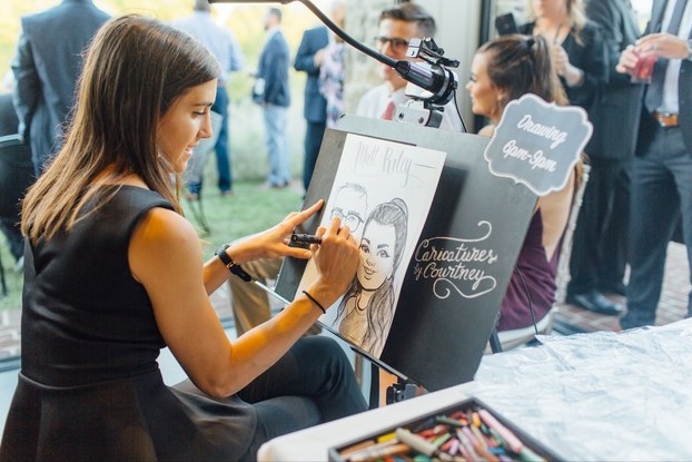Artist in black dress creates caricature drawing with black marker