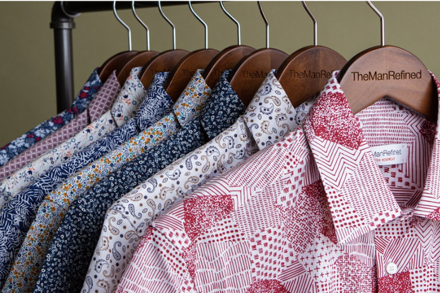 Multi-colored men's dress shirts hang on clothing rack