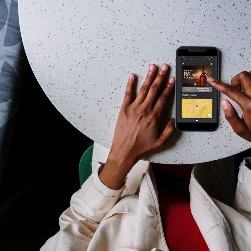 Person looking at digital 3x3 ad on smartphone.