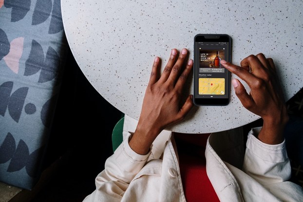 Person looking at digital 3x3 ad on smartphone.