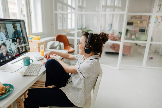 Woman working on computer on a video call in her house.