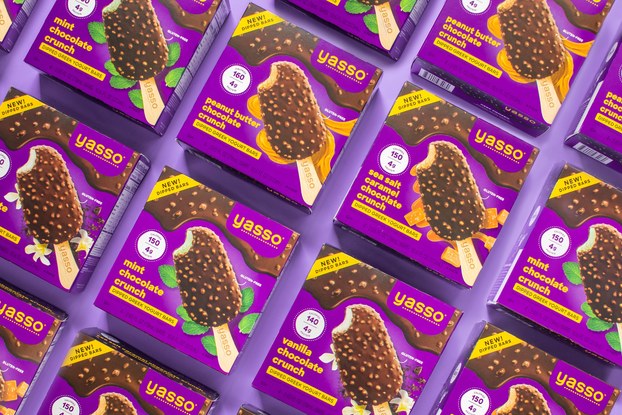 Boxes of Yasso frozen Greek yogurt pops in various flavors laid out.