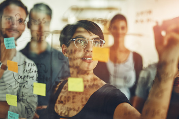 A group of young designers using sticky notes during a brainstorming session