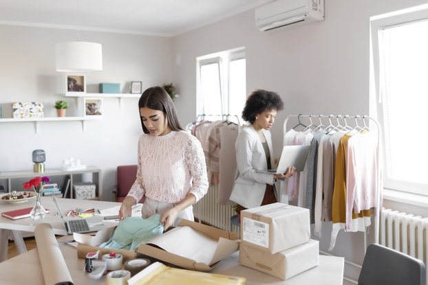 Two business owners inside workspace preparing orders.