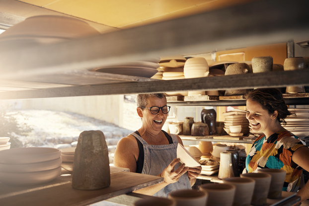 Business owner and employee working in kitchen of restaurant.