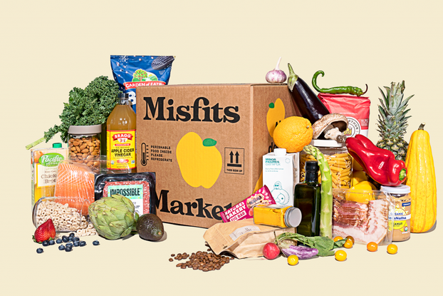 Misfits Market delivery box surrounded by produce and other food items the company sells.