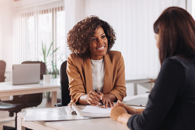 Woman meeting with another woman at a bank.