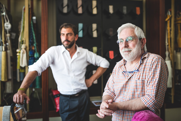Mature man with his son in their artisanal handicraft traditional textile factory