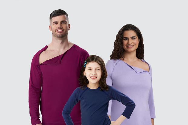 Three models wearing tops by Care+Wear that open for chest port access.