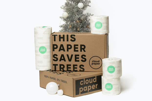 Boxes of Cloud Paper toilet paper on display in front of a Christmas tree.