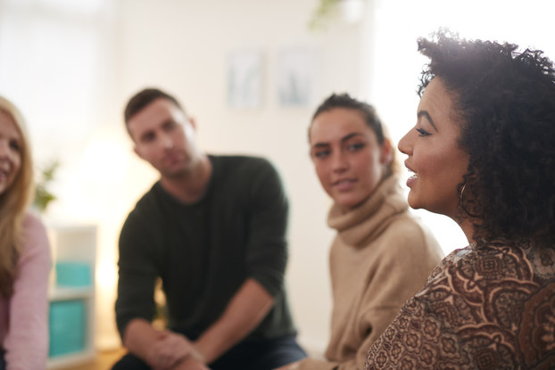Woman talks to group who intently listen