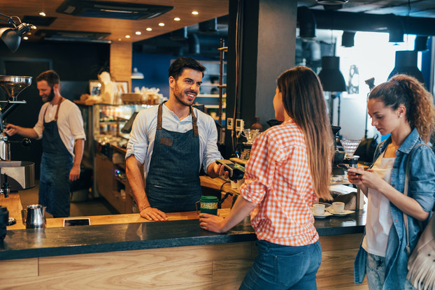Woman paying with credit card at a cafeteria.