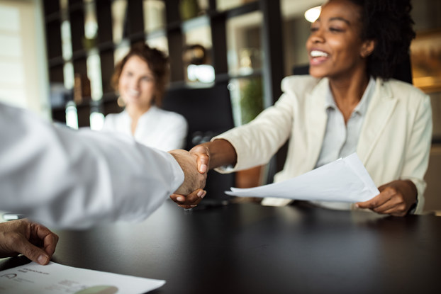 Business woman making agreement with an employee, shaking hands.