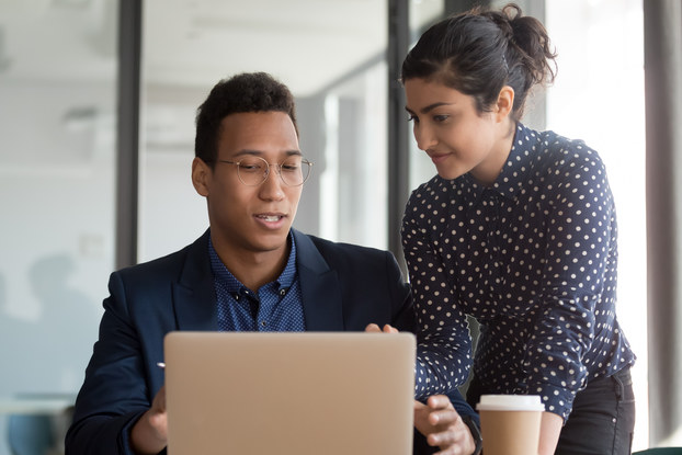 Businessman discussing project details with smiling colleague.
