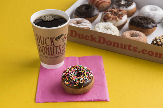 Duck Donuts' coffee and donuts on a table.